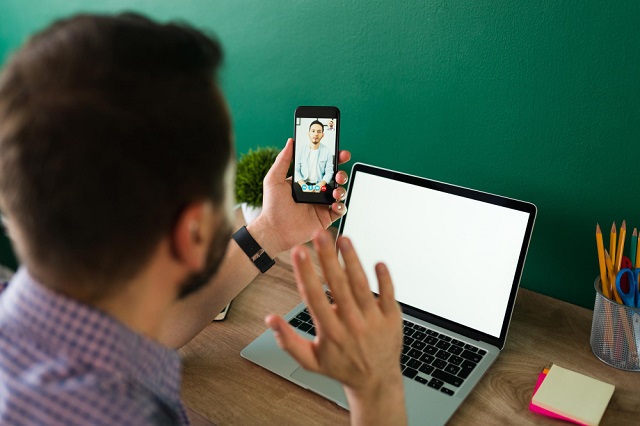 WhatsApp Web Video Calls Images/Pictures 2: Free photo of hello! adult man seen from behind talking during an online video call on his smartphone using a laptop. Image credit: tonodiaz on Freepik. https://www.freepik.com/free-photo/hello-adult-man-seen-from-talking-during-online-video-call-his-smartphone-using-his-laptop_27999438.htm#