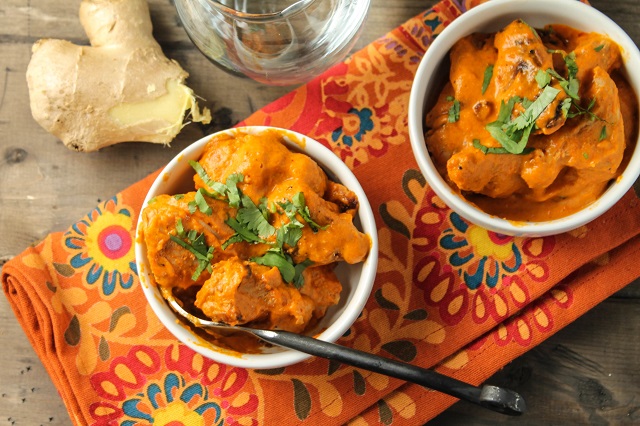 Image of Tender bits grilled and marinated chicken tikka are served in a tomato based and totally creamy masala sauce